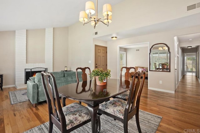 2072 Golden Circle Dr, Escondido, CA 92026 - dining area featuring a chandelier, light wood-style flooring, and a fireplace