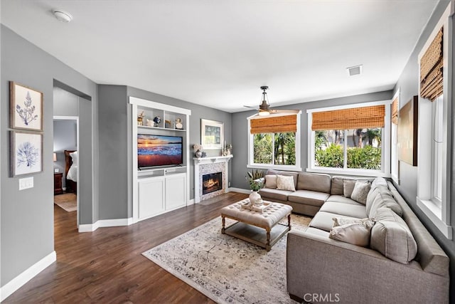 507 Corte Del Oro, San Clemente, CA 92673 - living room featuring dark wood finished floors, a glass covered fireplace, ceiling fan, and built in shelves
