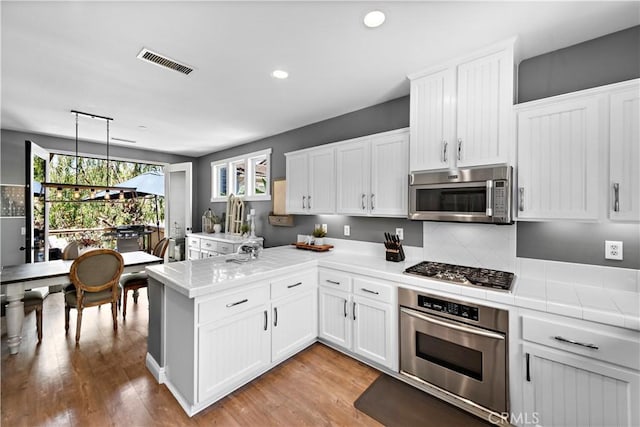 507 Corte Del Oro, San Clemente, CA 92673 - kitchen with stainless steel appliances, a peninsula, white cabinets, and recessed lighting