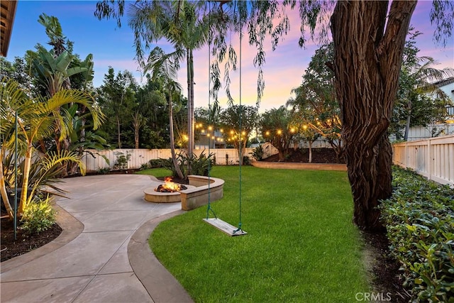507 Corte Del Oro, San Clemente, CA 92673 - yard at dusk with an outdoor fire pit, a patio area, and a fenced backyard