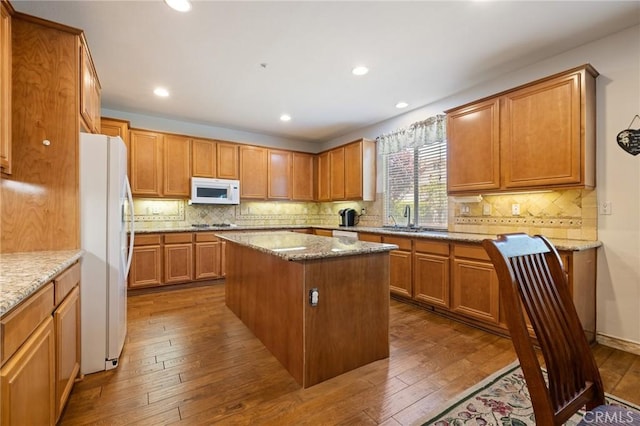 6411 Puma Pl, Rancho Cucamonga, CA 91737 - kitchen featuring white appliances, a kitchen island, dark wood-type flooring, recessed lighting, and light stone countertops