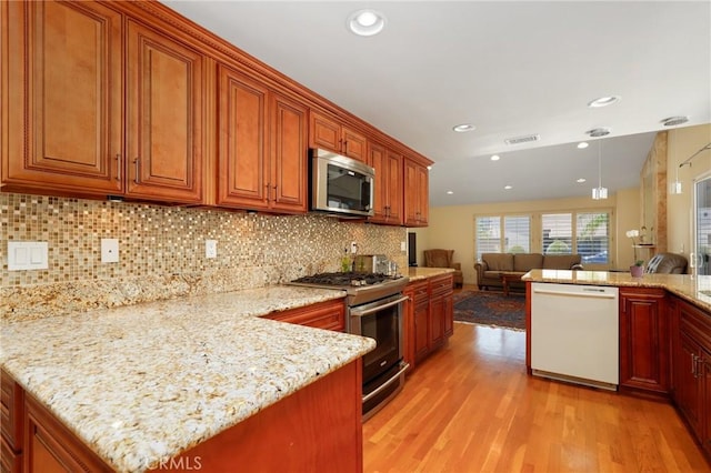 39 Foxhill, Irvine, CA 92604 - kitchen featuring appliances with stainless steel finishes, light wood-type flooring, open floor plan, a peninsula, and recessed lighting