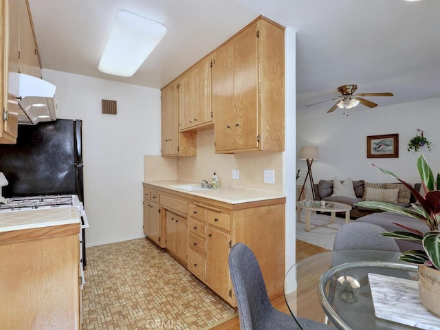 3042 E 3rd St Unit 5, Long Beach, CA 90814 - kitchen with tile counters, extractor fan, freestanding refrigerator, a ceiling fan, and decorative backsplash