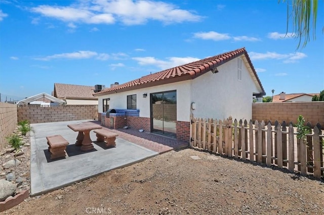 3920 Roxbury Dr, Hemet, CA 92545 - back of house featuring an outdoor kitchen, a fenced backyard, a patio area, stucco siding, and a tile roof