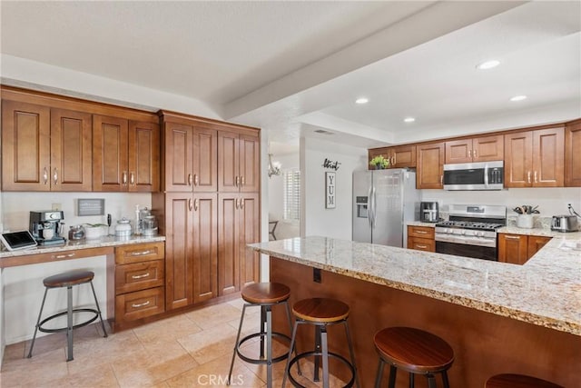 20241 Edmund Rd, Riverside, CA 92508 - kitchen featuring appliances with stainless steel finishes, brown cabinets, light stone counters, a peninsula, and recessed lighting