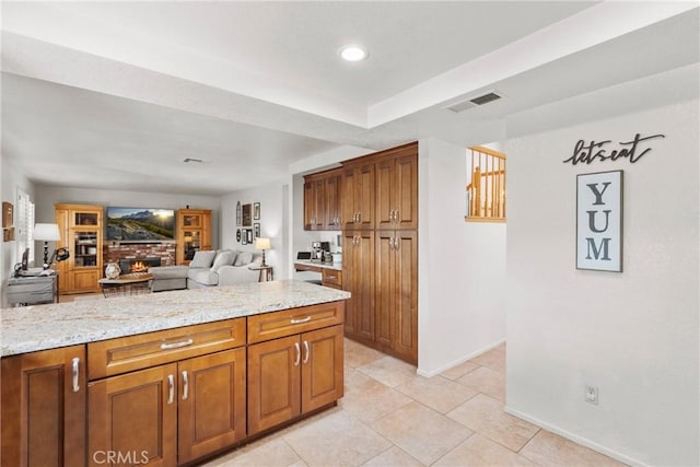 20241 Edmund Rd, Riverside, CA 92508 - kitchen with brown cabinetry, light tile patterned flooring, light stone countertops, and recessed lighting