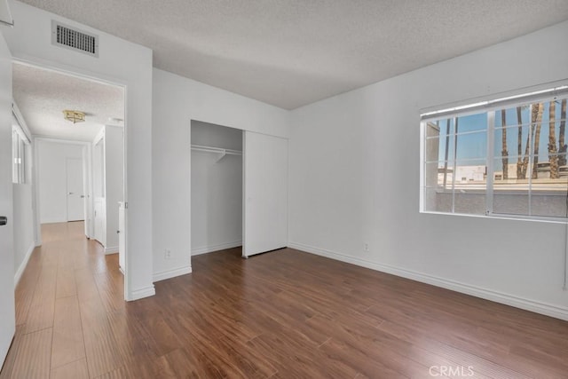 20155 Keswick St Unit 211, Winnetka, CA 91306 - unfurnished bedroom featuring a textured ceiling, wood finished floors, and a closet