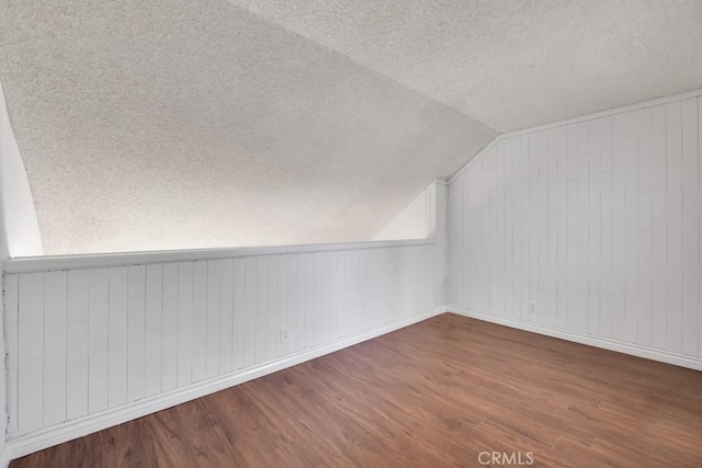 20155 Keswick St Unit 211, Winnetka, CA 91306 - additional living space with a textured ceiling, wood finished floors, lofted ceiling, and wooden walls