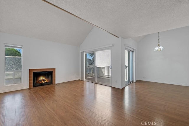 20155 Keswick St Unit 211, Winnetka, CA 91306 - unfurnished living room featuring lofted ceiling, wood finished floors, a tiled fireplace, and a textured ceiling
