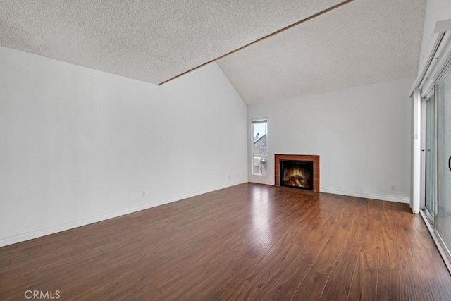 20155 Keswick St Unit 211, Winnetka, CA 91306 - unfurnished living room with a textured ceiling, dark wood finished floors, a tiled fireplace, and lofted ceiling