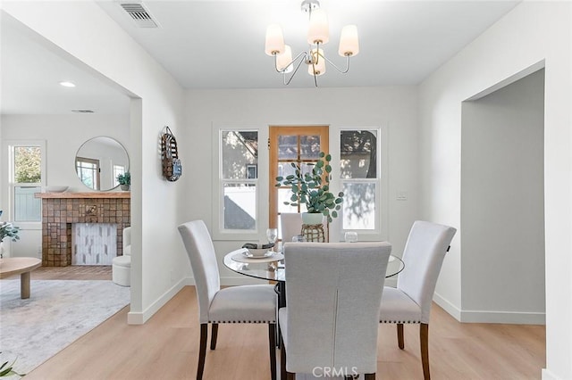 1951 Wagner St, Pasadena, CA 91107 - dining room featuring light wood-style floors, a chandelier, and a fireplace