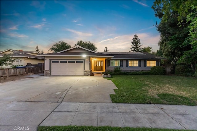 6330 N Wilson Ave, Fresno, CA 93704 - single story home featuring concrete driveway, a garage, solar panels, and stone siding