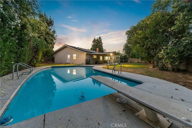 6330 N Wilson Ave, Fresno, CA 93704 - pool at dusk with a patio area, a fenced backyard, and a diving board