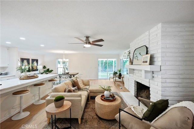 6330 N Wilson Ave, Fresno, CA 93704 - living area featuring light wood-style floors, a ceiling fan, a brick fireplace, and recessed lighting