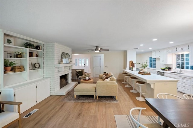 6330 N Wilson Ave, Fresno, CA 93704 - living room featuring light wood-style floors, plenty of natural light, a fireplace, a ceiling fan, and recessed lighting