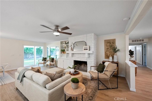 6330 N Wilson Ave, Fresno, CA 93704 - living room with light wood finished floors, ceiling fan, and a fireplace