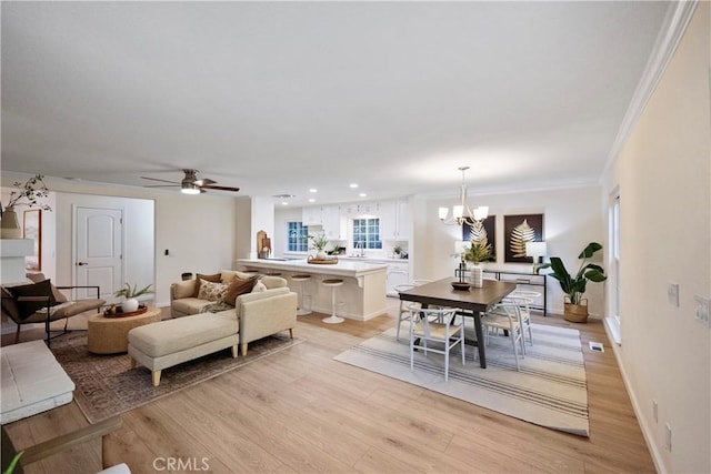 6330 N Wilson Ave, Fresno, CA 93704 - living room featuring light wood-style flooring, a chandelier, a ceiling fan, crown molding, and recessed lighting
