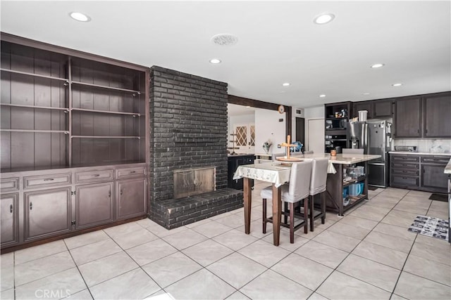 43657 21st St W, Lancaster, CA 93536 - kitchen with open shelves, stainless steel fridge with ice dispenser, black oven, light countertops, and light tile patterned flooring
