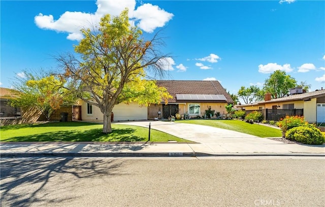43657 21st St W, Lancaster, CA 93536 - view of front of home with driveway, an attached garage, a tiled roof, stucco siding, and solar panels