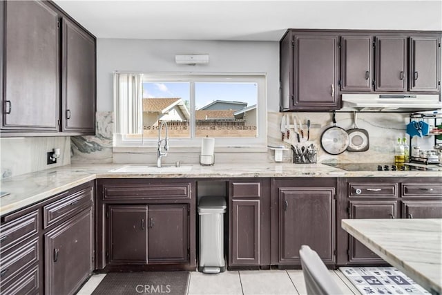 43657 21st St W, Lancaster, CA 93536 - kitchen featuring under cabinet range hood, black electric cooktop, tasteful backsplash, and dark brown cabinetry