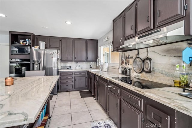43657 21st St W, Lancaster, CA 93536 - kitchen with black appliances, tasteful backsplash, light stone countertops, under cabinet range hood, and dark brown cabinetry