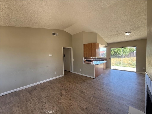15569 Athol St, Fontana, CA 92335 - kitchen with open floor plan, wood finished floors, brown cabinets, a textured ceiling, and vaulted ceiling