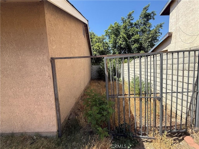 15569 Athol St, Fontana, CA 92335 - view of property exterior with stucco siding and a gate
