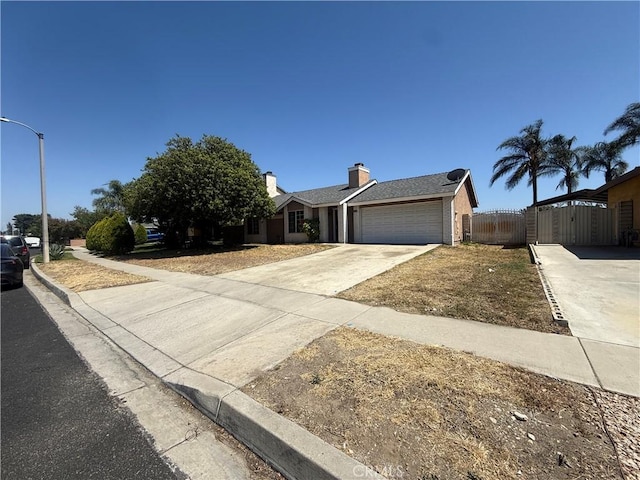 15569 Athol St, Fontana, CA 92335 - single story home with an attached garage, concrete driveway, a gate, and a chimney