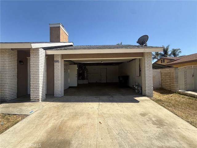 15569 Athol St, Fontana, CA 92335 - view of side of home featuring driveway, a chimney, an attached garage, and brick siding