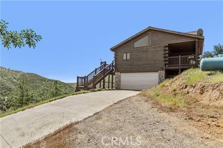 7385 Cosmit Ln, Julian, CA 92036 - view of side of property with driveway, an attached garage, stairs, and log siding