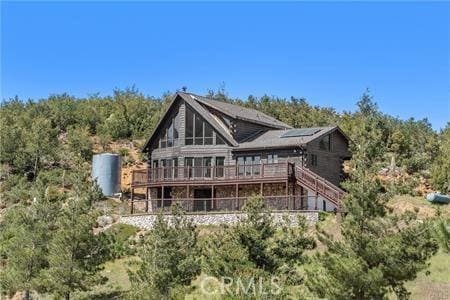 7385 Cosmit Ln, Julian, CA 92036 - back of property featuring a deck, roof mounted solar panels, and a view of trees