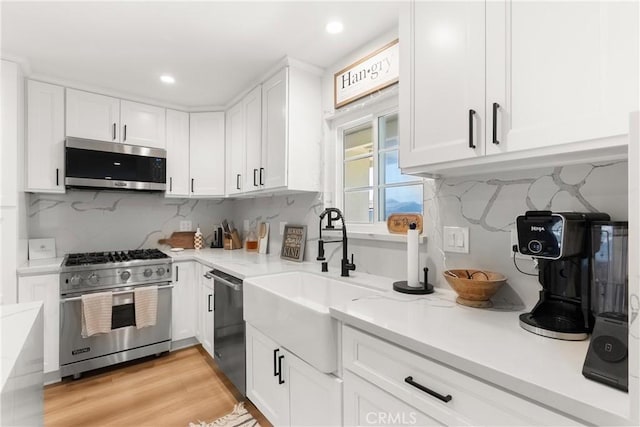 10171 Kukui Dr, Huntington Beach, CA 92646 - kitchen with stainless steel appliances, white cabinetry, backsplash, recessed lighting, and light wood finished floors