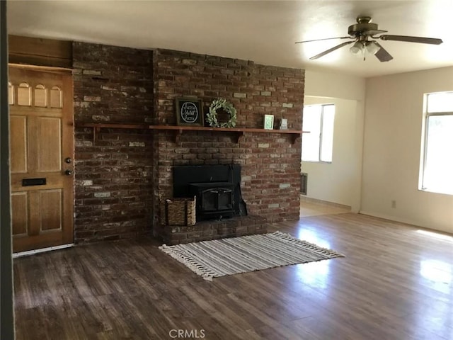2911 Tahoe Dr, Merced, CA 95340 - unfurnished living room featuring a wood stove, healthy amount of natural light, wood finished floors, and a ceiling fan