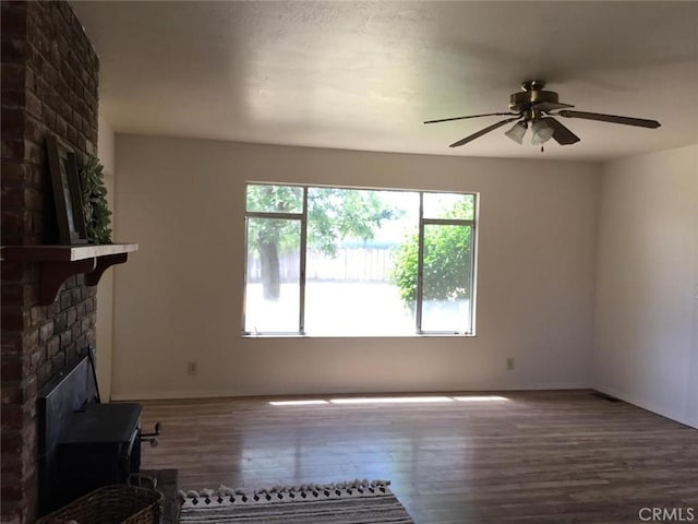 2911 Tahoe Dr, Merced, CA 95340 - unfurnished living room featuring wood finished floors, ceiling fan, and a brick fireplace