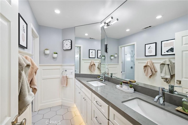 2 Sun Ter, Laguna Niguel, CA 92677 - full bath featuring a decorative wall, double vanity, a wainscoted wall, tile patterned flooring, and a shower
