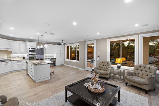 2 Sun Ter, Laguna Niguel, CA 92677 - living area featuring crown molding, recessed lighting, light wood-style flooring, wine cooler, and a ceiling fan