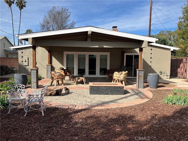 6914 Andasol Ave, Van Nuys, CA 91406 - rear view of property with stucco siding, a patio area, a chimney, and french doors