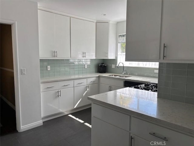 6914 Andasol Ave, Van Nuys, CA 91406 - kitchen with decorative backsplash, light stone countertops, and white cabinets