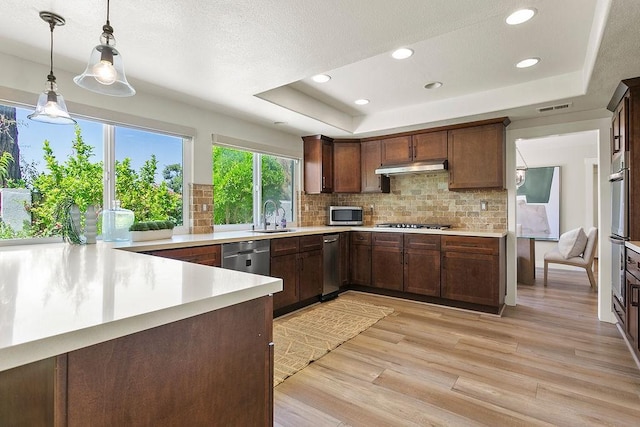 245 S Via Montanera, Anaheim Hills, CA 92807 - kitchen featuring stainless steel appliances, a raised ceiling, light countertops, backsplash, and recessed lighting