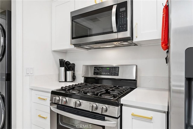11521 Double Eagle Dr, Whittier, CA 90604 - kitchen featuring stainless steel appliances, stacked washer / drying machine, white cabinetry, and light countertops