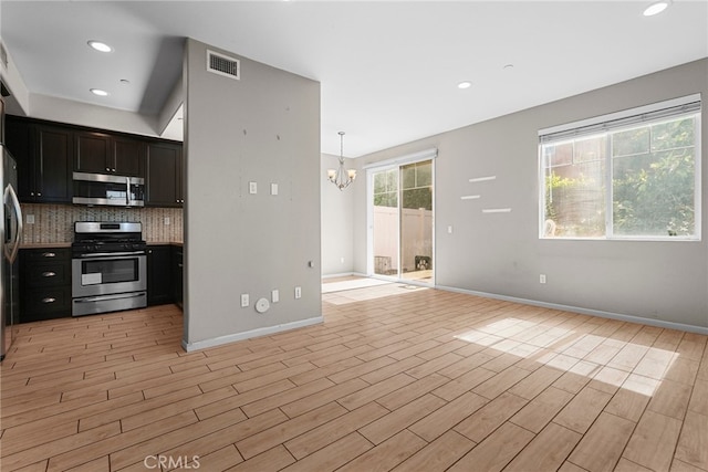 7600 N Courage Way, Van Nuys, CA 91405 - kitchen with stainless steel appliances, a chandelier, backsplash, light wood-type flooring, and open floor plan