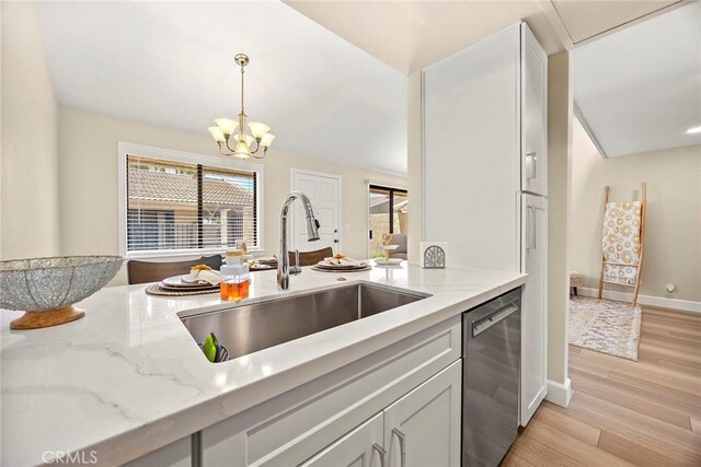 4692 Lakeview Ave Unit 8, Yorba Linda, CA 92886 - kitchen with stainless steel dishwasher, light stone countertops, light wood-type flooring, and pendant lighting