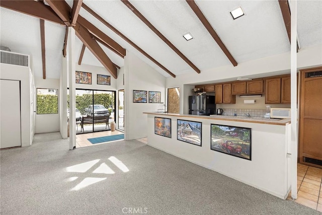 4692 Lakeview Ave Unit 8, Yorba Linda, CA 92886 - kitchen with freestanding refrigerator, high vaulted ceiling, white microwave, beam ceiling, and light colored carpet