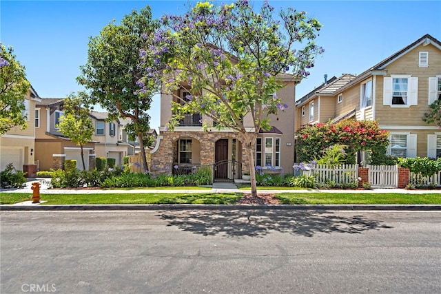 81 Mercantile Way, Ladera Ranch, CA 92694 - multi unit property with a fenced front yard, a gate, stone siding, stucco siding, and a residential view