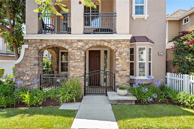 81 Mercantile Way, Ladera Ranch, CA 92694 - entrance to property with a balcony, stucco siding, stone siding, and a gate