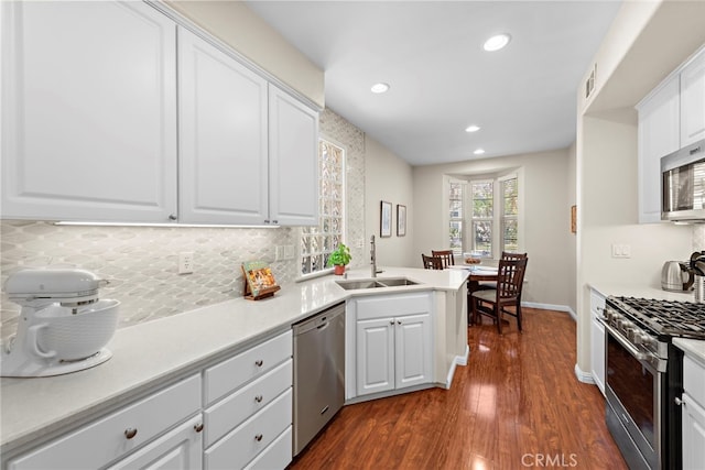 81 Mercantile Way, Ladera Ranch, CA 92694 - kitchen featuring appliances with stainless steel finishes, tasteful backsplash, recessed lighting, dark wood-style flooring, and white cabinets