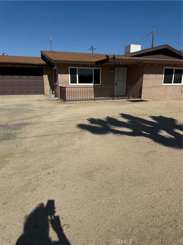 7395 Sage Ave, Yucca Valley, CA 92284 - view of front of house with a garage, stucco siding, and driveway