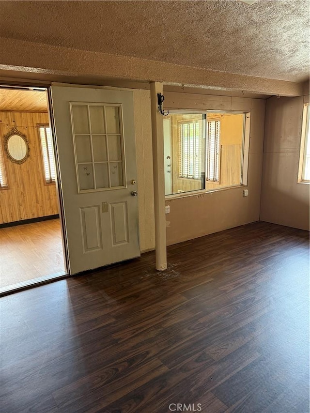 7395 Sage Ave, Yucca Valley, CA 92284 - entrance foyer with dark wood-type flooring, wooden walls, and a textured ceiling