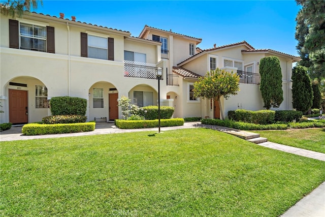 811 Larkridge, Irvine, CA 92618 - view of front of home featuring stucco siding, a front lawn, a tiled roof, and a balcony