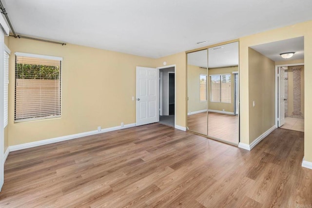 5983 Gaines St, San Diego, CA 92110 - unfurnished bedroom with light wood-style flooring and a closet